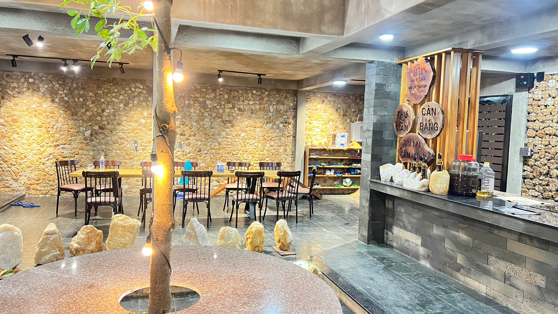 Gian sinh hoạt chung với bàn ăn gỗ và tường đá thạch anh Gian sinh hoạt chung với bàn ăn gỗ và tường đá thạch anh