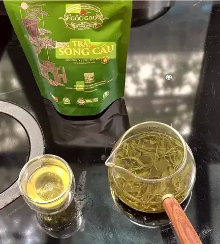 Nước trà xanh và lá chè đã pha trong ấm thuỷ tinh