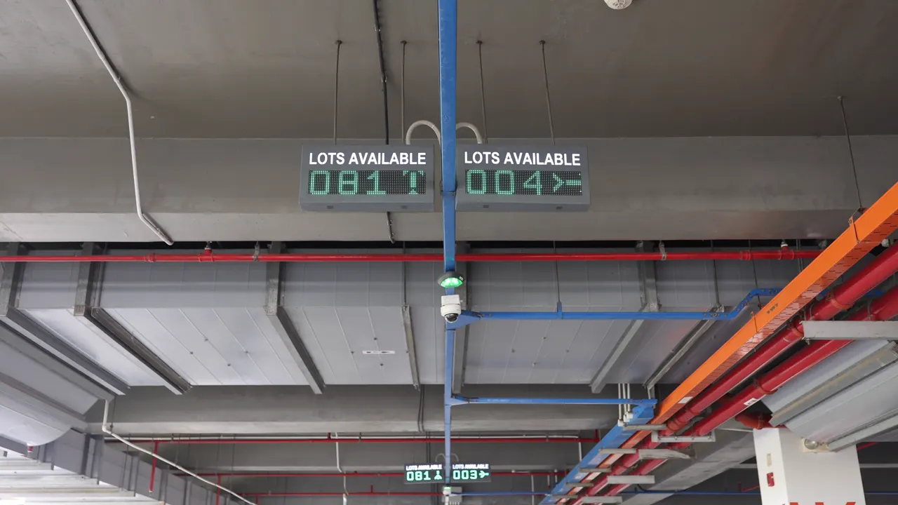 Hai bảng LED Lots Available treo trần trong bãi xe, báo số chỗ trống theo từng hướng