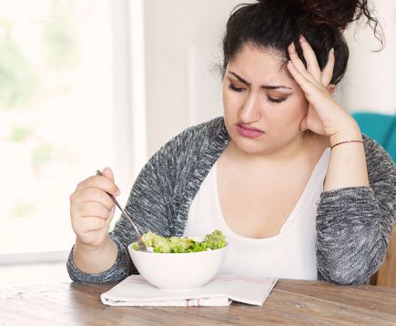 Woman looking at a bowl of salad