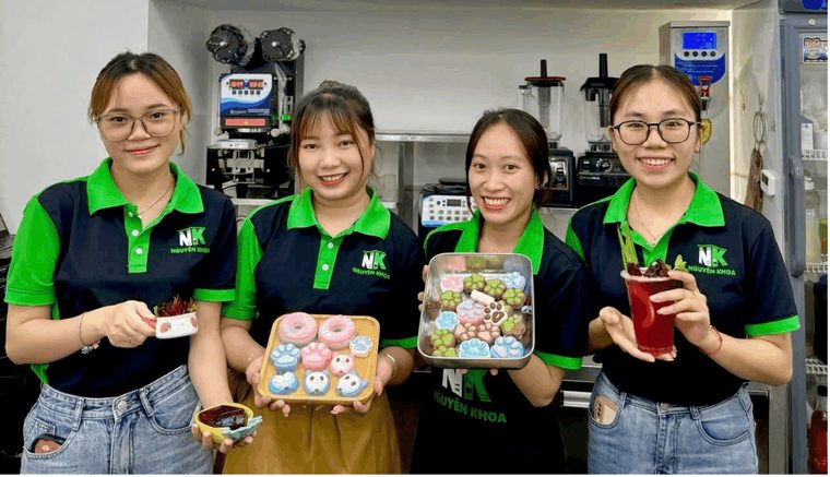 Doi ngu nhan vien Nguyen Khoa F&B trong dong phuc ao thun co xanh