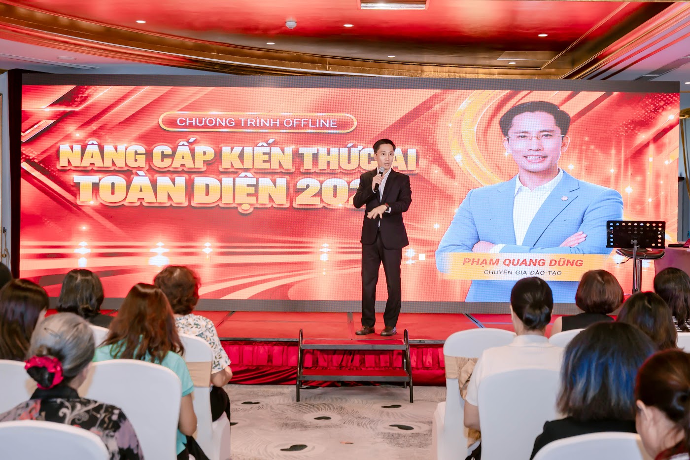 Phạm Quang Dũng mặc áo đen đứng dạy trên sân khấu
