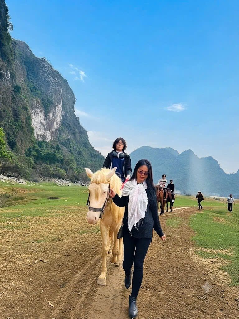 Chị Nguyễn Thúy Bình dắt ngựa cho con trong một chuyến đi giữa núi