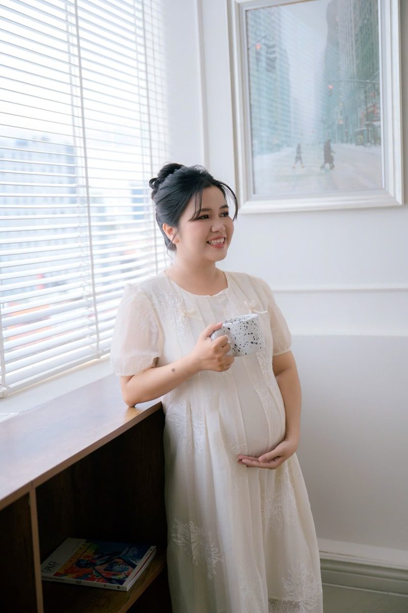 Chị Phan Huệ khi mang thai, đứng cạnh cửa sổ