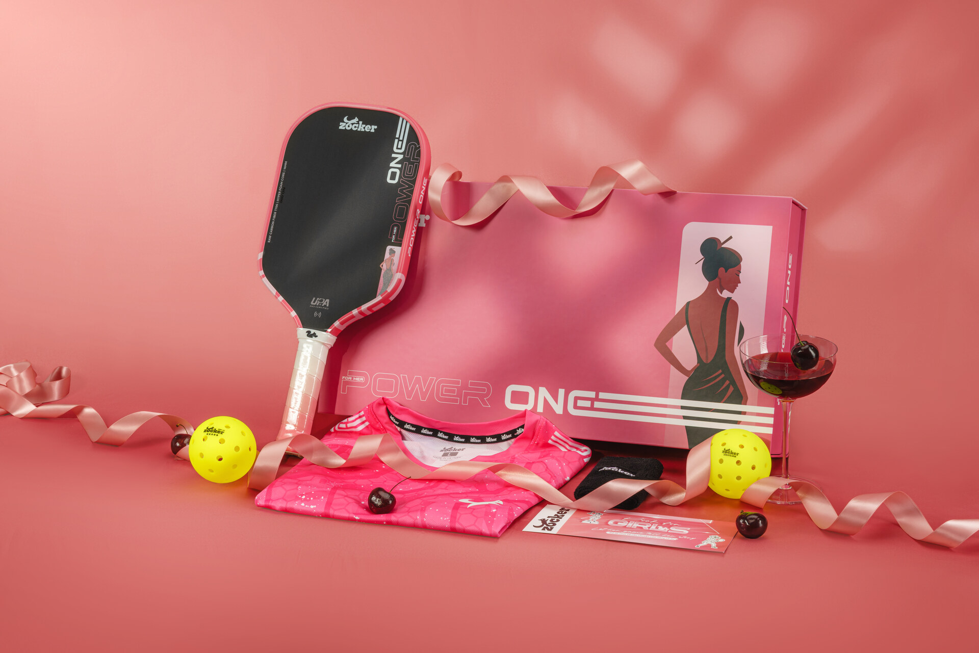 Set Power One: vợt, áo, băng chặn và hai bóng trên nền hồng cá tính