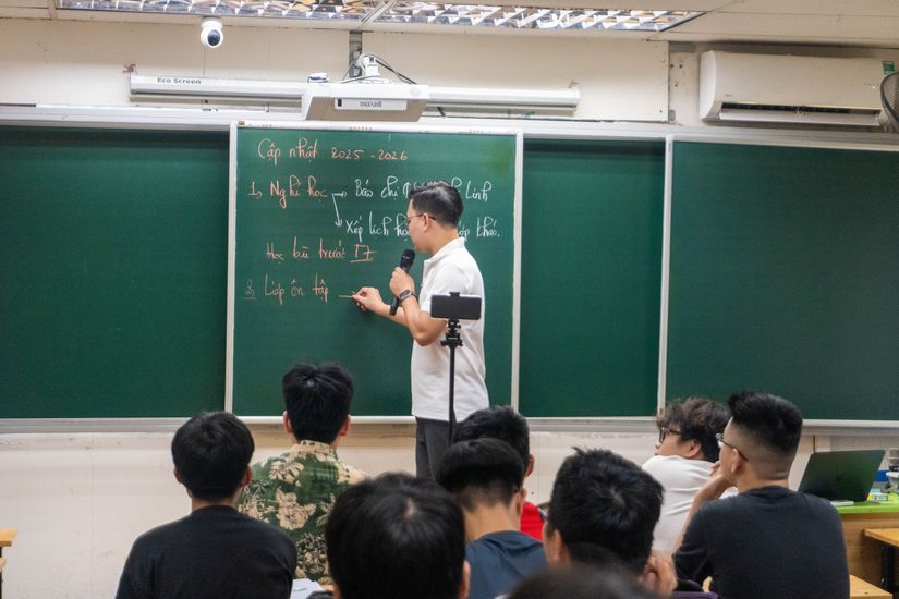 Thầy giáo VLSN đứng giảng bài, tương tác với học sinh trong lớp