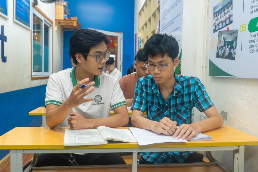 Trợ giảng kèm học sinh làm bài tập tại bàn học